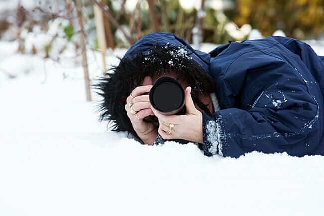 mom in snow photographing children