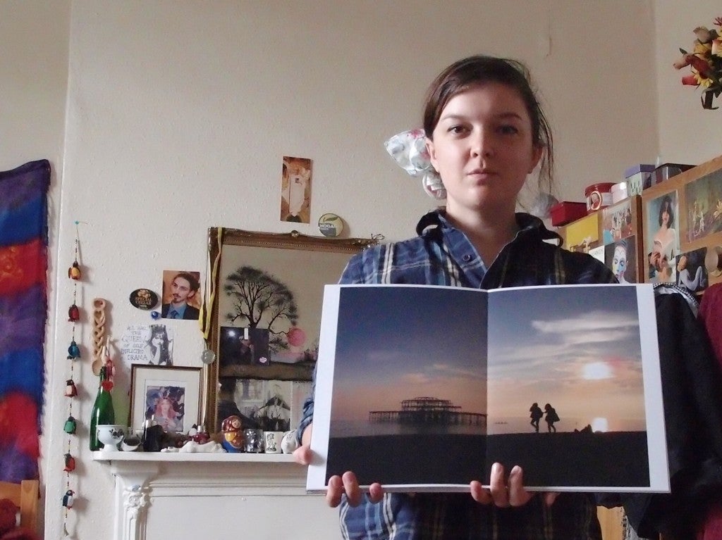 Lucy holds a portfolio of her photography.