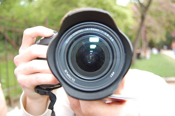 A closeup of a photographer and their camera.