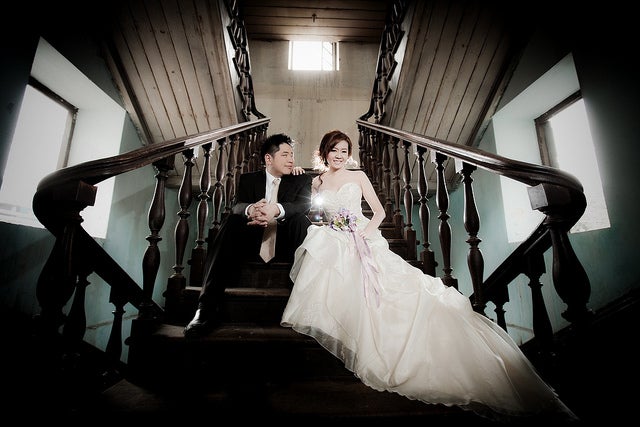 A bride and groom sitting on the stairs.