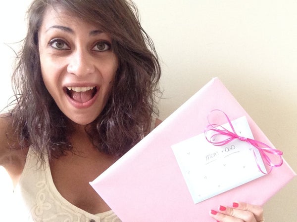 A woman excitedly holding pictures of her family vacation.