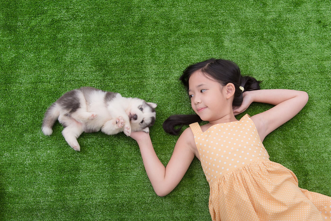 girl in grass with dog