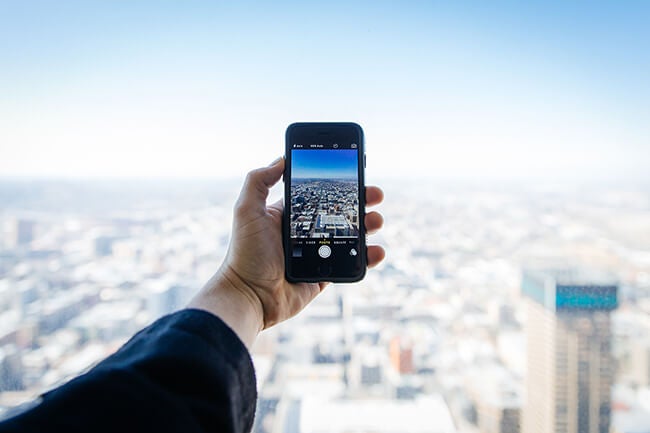 man holding phone vacation picture