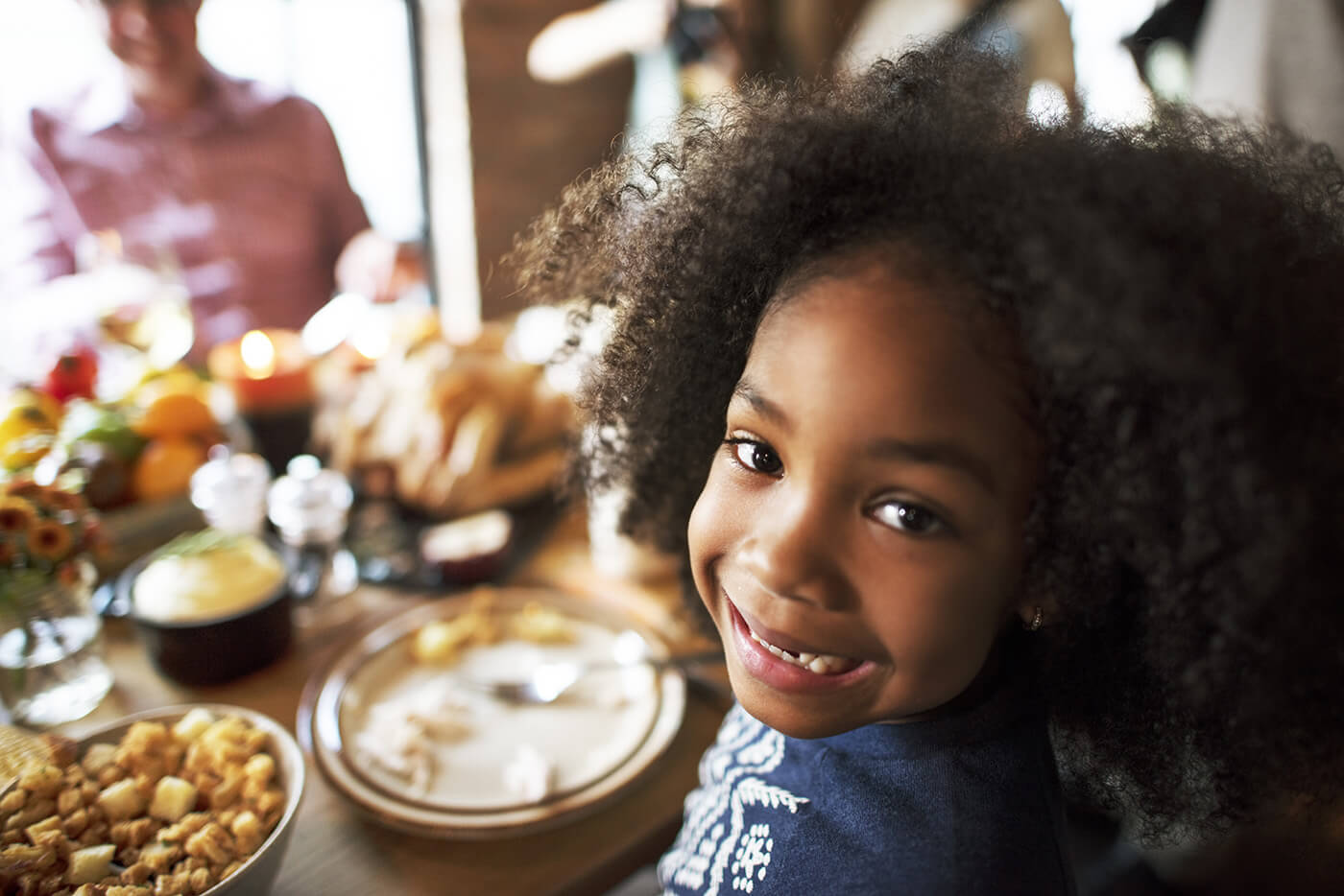 little girl looking into camera at table