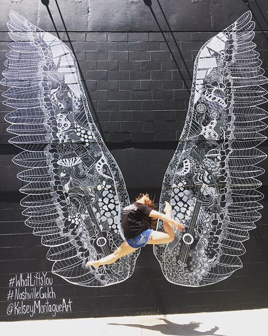 woman jumping in front of wing wall