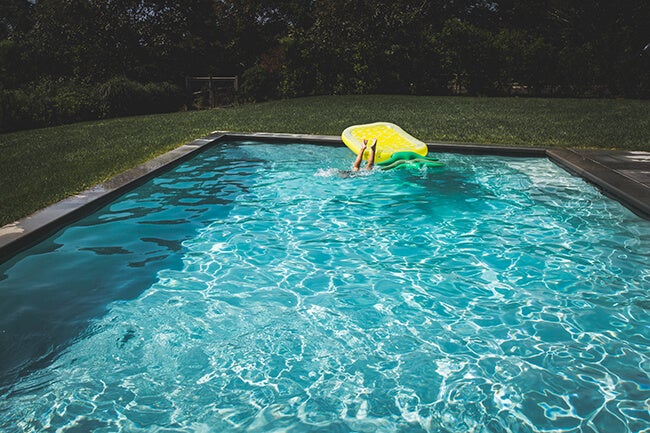 child diving into pool