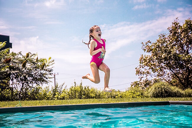 child jumping into pool