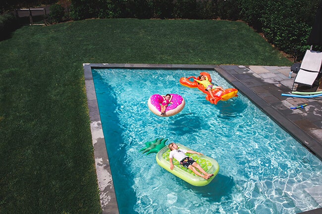 three kids in pool with floaties