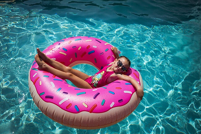 girl on donut floatie in pool