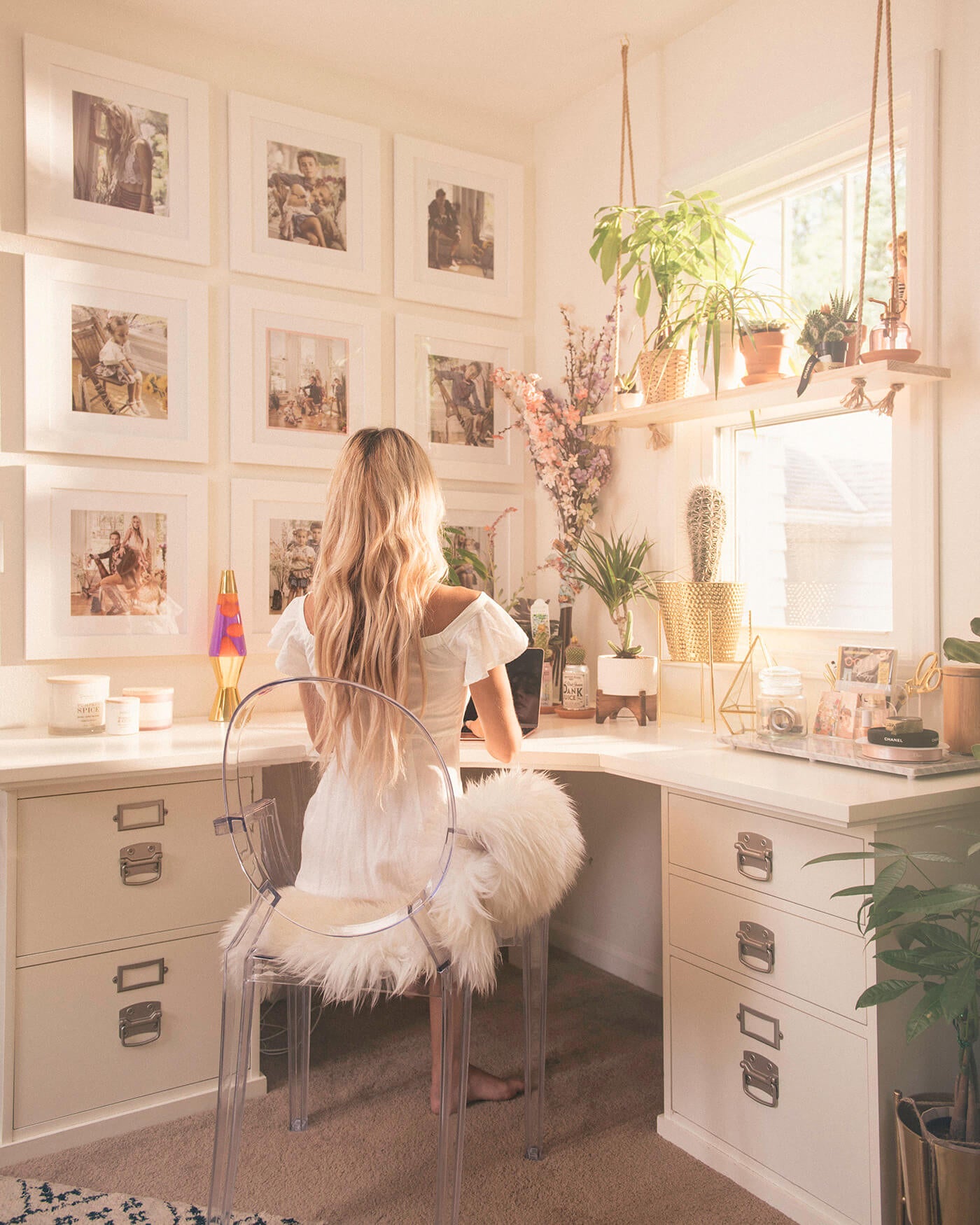 wooman sitting at desk in front of wall gallery printed by printique