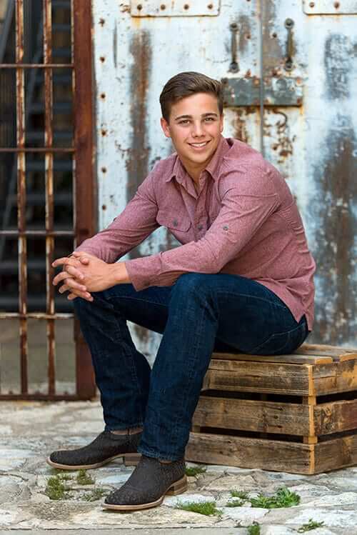 high school senior boy posing on crate