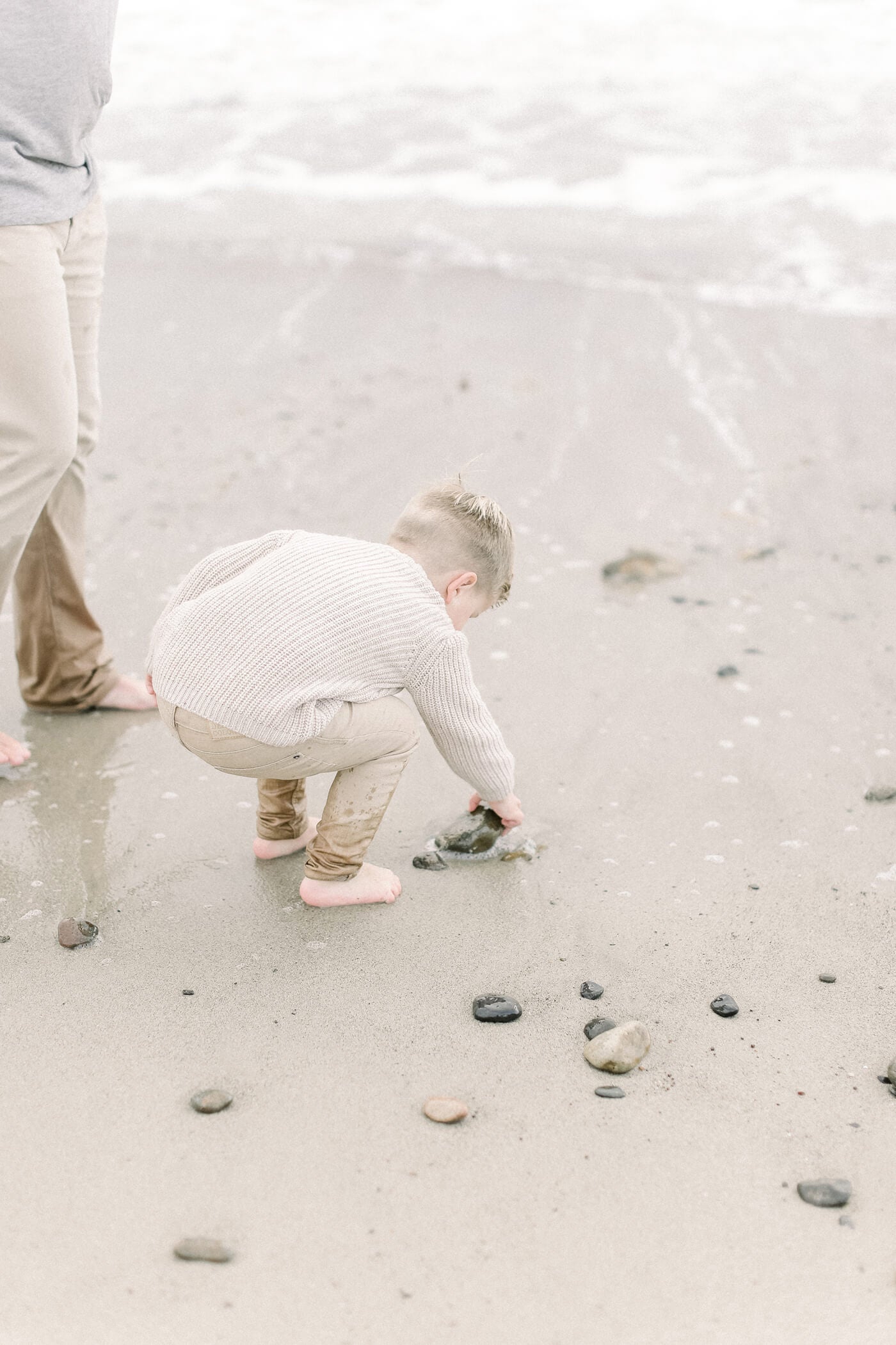 boy collecting rocks for his beach portrait