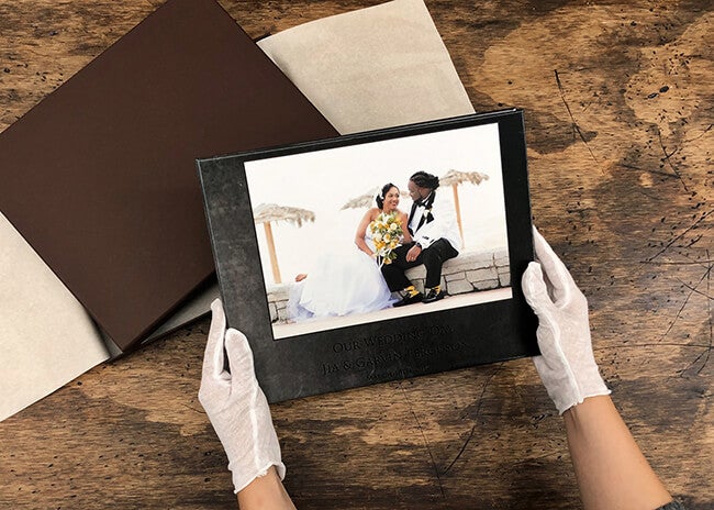 person holding wedding album manufactured by Printique