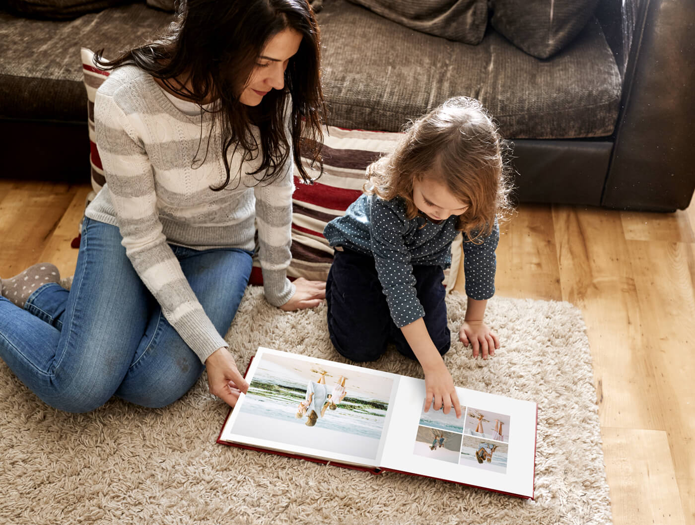 mom and child looking through family photo book by printique