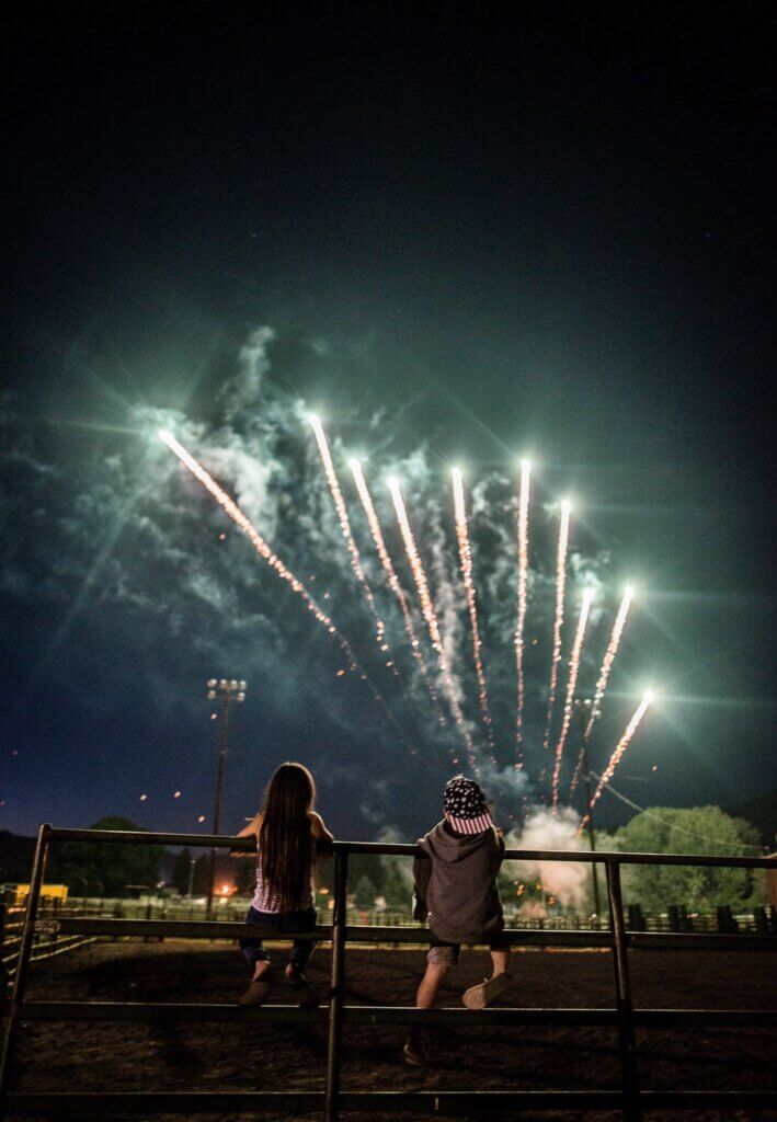 Two kids watch fireworks during the summer in a small souther USA town.