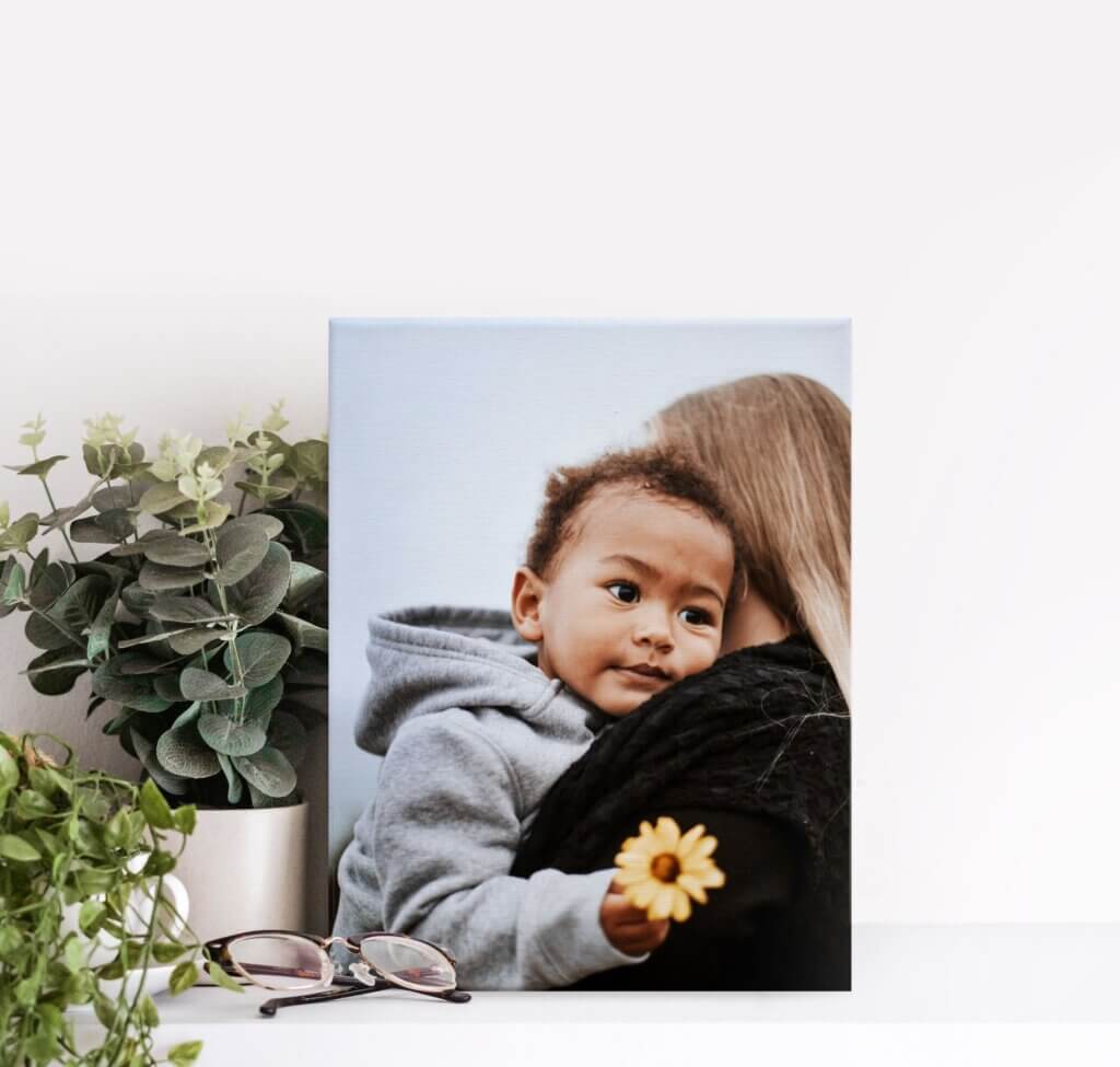 Canvas print of little boy holding flower.