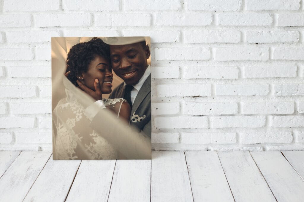 Man holds woman face in a canvas wedding photo.