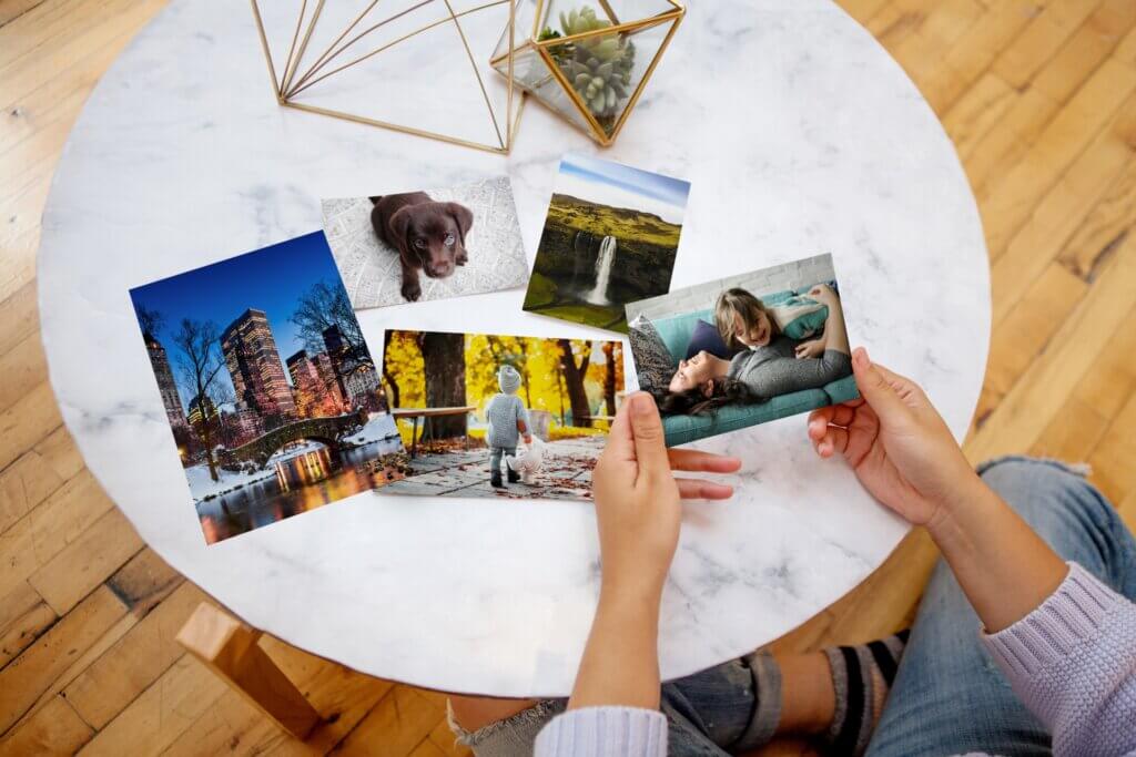 Woman looks at classic photo prints on coffee table.