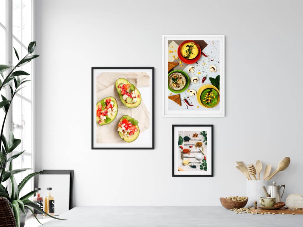 Photo gallery of food - stuffed avocados, seasoning, and mushroom dips - used as wall decor in a kitchen.