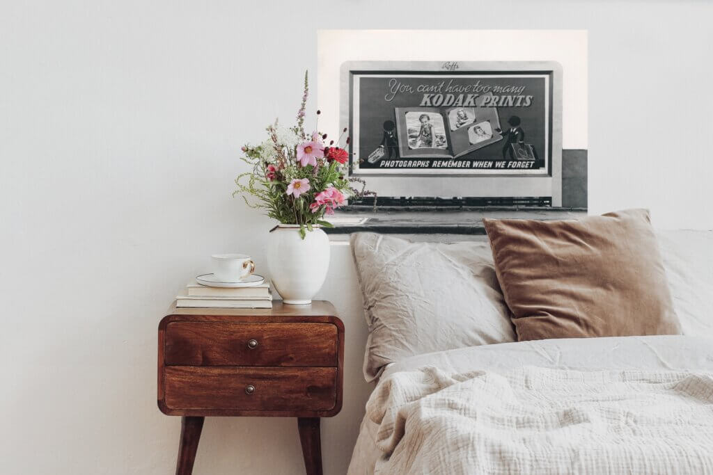 A vintage kodak free printable hangs above a bed, adding charm and personalization to otherwise empty walls.