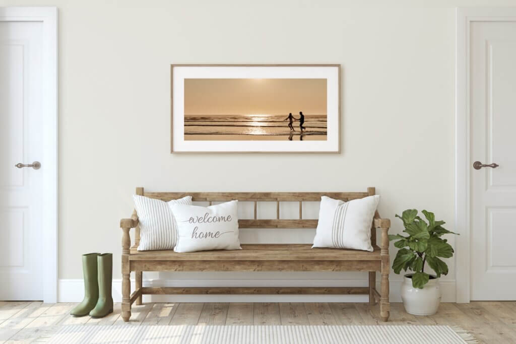 Mudroom decorating done with a long horizontal frame displaying a couple running on the beach.
