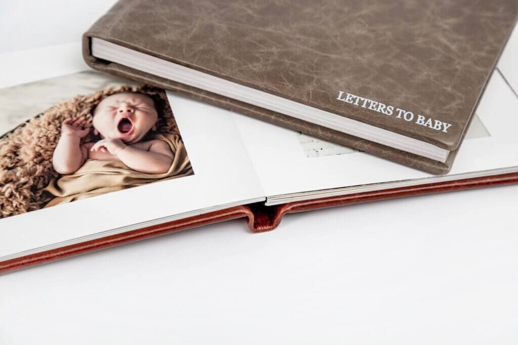 Two premium custom photo books with baby picture inside.