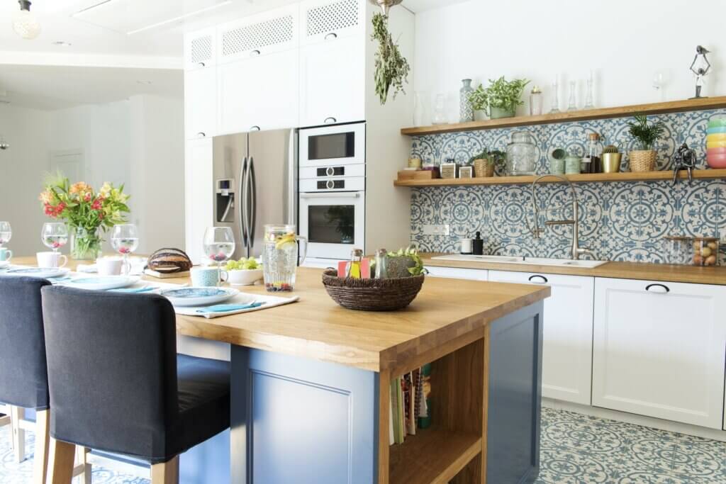 A beautifully patterned tile covers the kitchen floor and walls in this Mediterranean styled home.