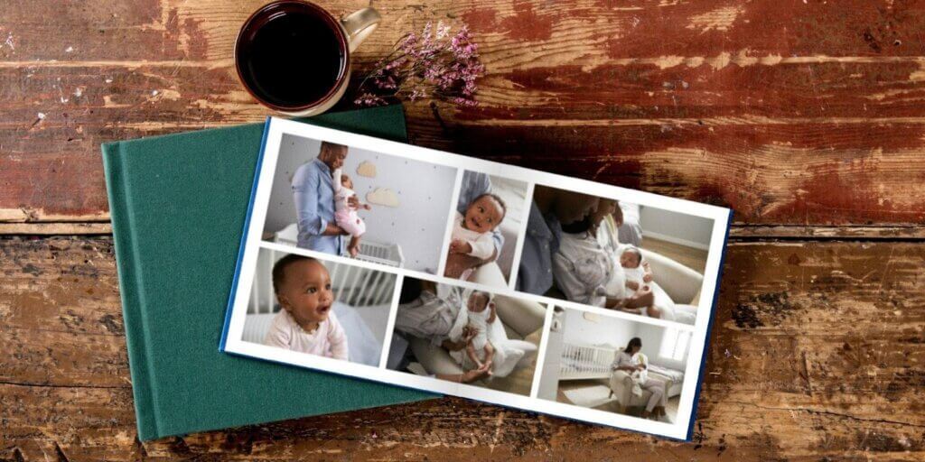 A collage of beautiful baby photos spans two pages in a fabric cover baby photo book.