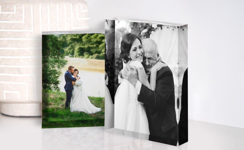 A custom acrylic print of a bride hugger her father decorates counter space.