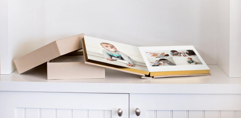 A family photo album with gold gilded pages sits open on counter space.