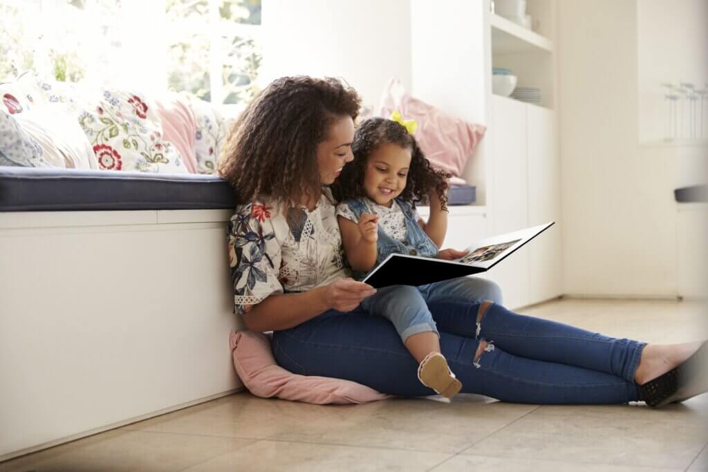 Mother and daughter laugh together as they relive memories in a photo book.