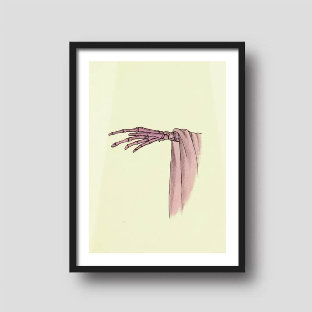 Free printable art of a pink skeleton hand, displayed on a framed print.